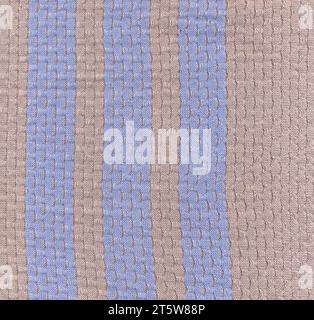 High detailed fabric texture of light brown color with blue stripes background. Stock Photo