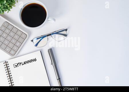 Work from home. Desk office with laptop, calculator, blank notepad, coffee cup and pen on wood table. Flat lay top view copy space. Stock Photo