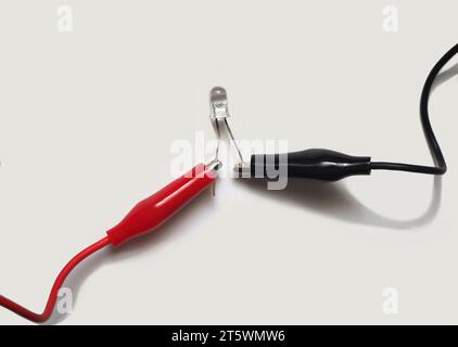 LED attached to red and black wires. Light-emitting diode or LED on a white background. Stock Photo