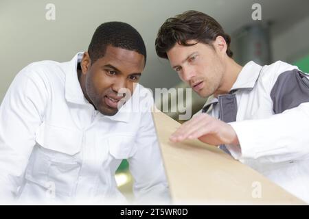 two craftsmen working in team and cutting wood Stock Photo