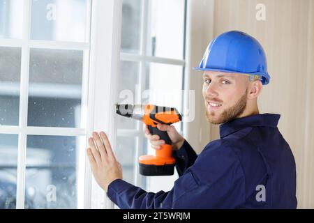 contractor using a cordless drill on a patio door Stock Photo