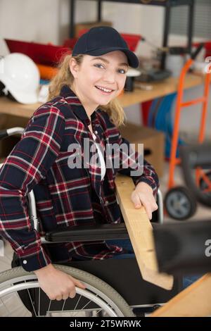 disabled worker in wheelchair in a carpenters workshop Stock Photo