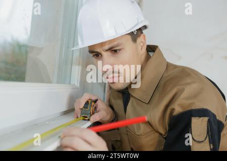 portrait of man during installation of plastic windows Stock Photo