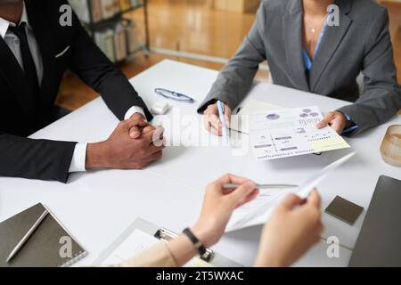 Hands of entrepreneurs discussing charts and reports at meeting Stock Photo