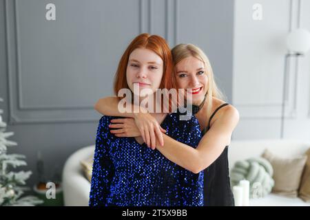 Two beautiful girls. Models posing near decorated Christmas tree at New Year eve.  Stock Photo