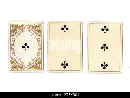 Three antique playing cards showing an ace, two and three of clubs on a white background. Stock Photo
