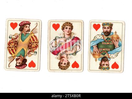 Three antique playing cards showing a jack, queen and king of hearts on a white background. Stock Photo