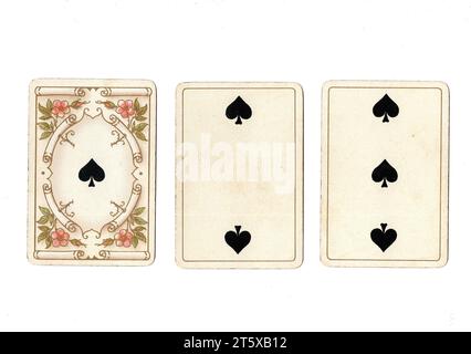 Three antique playing cards showing an ace, two and three of spades on a white background. Stock Photo