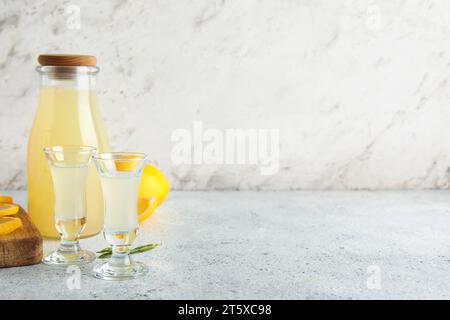 Bottle and shots of tasty Limoncello on white background Stock Photo