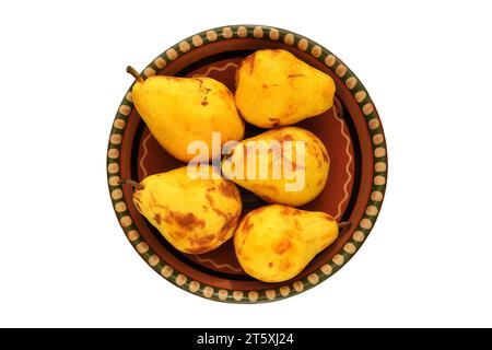 Pears in a clay beige plate. Farm pears in rustic bowl. Isolate on a white background. Top view. Stock Photo