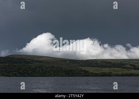 A dramatic white cloud like a breaking wave over the Isle of Bute, seen against the dark sky of an approaching storm (Scotland, UK) Stock Photo
