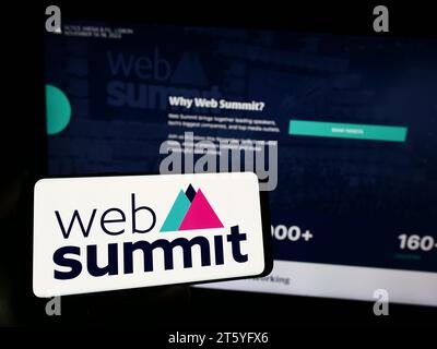 Person holding smartphone with logo of annual technology conference Web Summit (Lisbon) in front of website. Focus on phone display. Stock Photo
