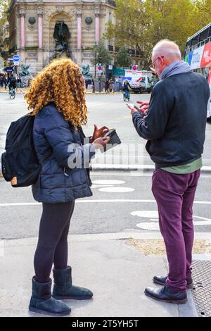 Tourists checking directions on their smartphones - Paris, France. Stock Photo