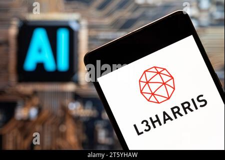 In this photo illustration, the American defense contractor, information technology services provider, and technology company, L3Harris Technologies (NYSE: LHX), logo seen displayed on a smartphone with an Artificial intelligence (AI) chip and symbol in the background. Stock Photo