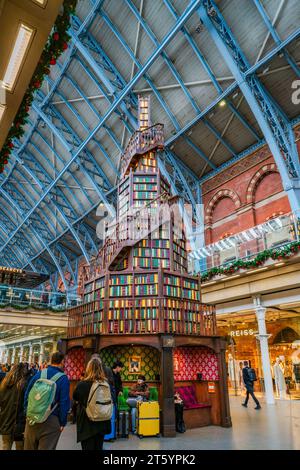 LONDON, UK - NOVEMBER 07, 2023: This year’s St. Pancras International Christmas Tree features a winding staircase and 270 shelves adorned with over 3, Stock Photo