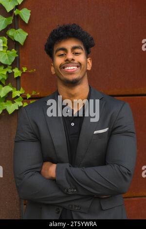 Vertical portrait of a successful young entrepreneur smiling at camera with arms crossed Stock Photo
