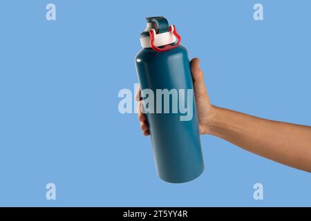 Black male holding thermo bottle canteen on light blue background Stock Photo