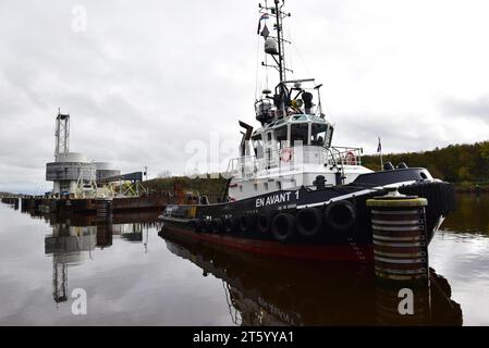 Tugboat towing a pontoon with offshore installation in the Kiel Canal, Schleswig-Holstein, Germany Stock Photo