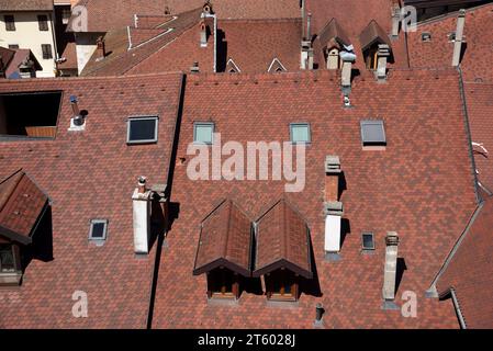 Typical Scalloped Roof Tiles, Tall Chimneys, Roof Windows, Dormer Window & Rooftops of the Old Town or Historic District of Annecy Haute Savoie France Stock Photo