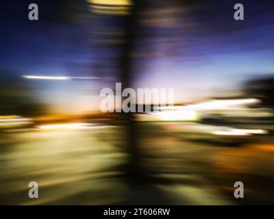 Blurred car driving fast in modern city night background. Defocused shot of  car wheel drifting on night of city. Stock Photo