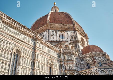 Detail of the Florence cathedral Santa Maria del Fiore with Brunelleschi's dome in the center at dawn on a day with blue sky Stock Photo