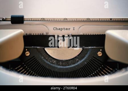 Vintage typewriter with a paper sheet, typed word chapter 1, concept for storytelling and creative writing, copy space, selected focus, very narrow de Stock Photo