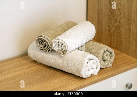 Clean folded towels on a shelf inside hotel room interior Stock Photo