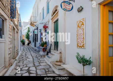 Narrow alley with whitewashed traditional houses and shops in Pyrgos, the biggest and most charming village in mountainous Tinos, Cyclades, Greece. Stock Photo
