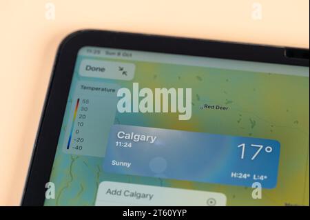 New York, USA - October 8, 2023: Checking temperature outside in Calgary city on online app ipad tablet screen close up view Stock Photo