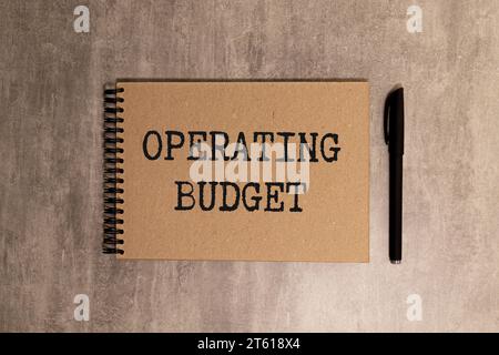 Closeup on businessman holding a card with text OPERATING BUDGET, business concept image with soft focus background and vintage tone. Stock Photo