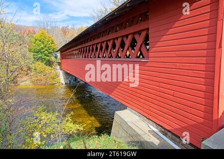 The 1840 wooden Henry covered bridge over Walloomsac River a 121 feet  single-span Town lattice truss structure in autumn Stock Photo