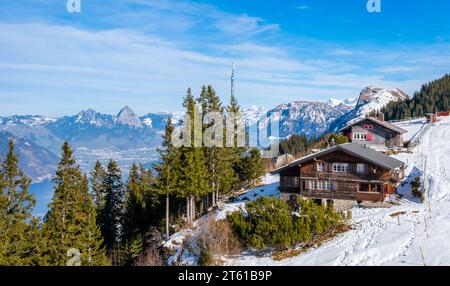 Lodge on Klewenalp mountain in Swiss Alps, Switzerland in winter. Lake Lucerne or Vierwaldstattersee and fir forest. Popular ski resort and winter Stock Photo