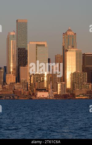 Seattle, WA, USA - October 28, 2023; Sunset golden light reflecting on tall skyscapers in downtown Seattle across Elliott Bay Stock Photo