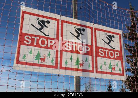 Warning sign to stop skiing because of trees and deer (Verbier, Switzerland) Stock Photo