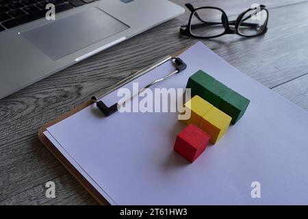Closeup image of paper clipboard and wooden cubes. Business graph chart, growth and profit concept. Stock Photo