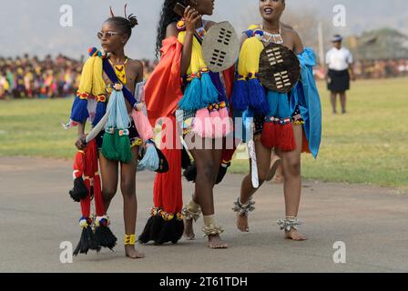 Three young women in traditional Swazi dress at Umhlanga reed dance ceremony, kingdom of Eswatini, people walking, females in cultural clothes, ethnic Stock Photo
