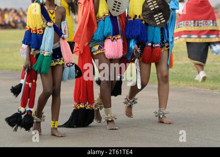 Three young women in traditional Swazi dress at Umhlanga reed dance ceremony, kingdom of Eswatini, people walking, females in cultural clothes, ethnic Stock Photo