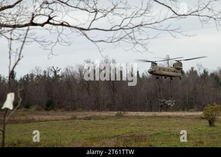 A U.S. Army CH-47F Chinook helicopter from the 10th Combat Aviation Brigade, 10th Mountain Division drops off a M777A2 Howitzer during a two-gun raid dry fire exercise on Fort Drum, New York, Nov. 6, 2023. The exercise validates the battery’s ability to conduct a platoon raid and build competency and knowledge of air assault operations. (U.S. Army Photo by Salvador Castro) Stock Photo