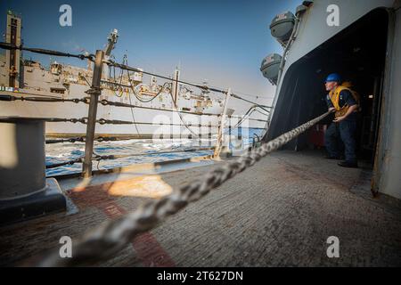 October 16, 2023 - Virginia, USA: Sonar Technician (Surface) 2nd Class Clayton Pettit, from Virginia Beach, Virginia, assigned to the Arleigh Burke-class guided-missile destroyer USS Carney (DDG 64), heaves around a line during a replenishment-at-sea with the Lewis and Clark-class dry cargo and ammunition ship USNS Medgar Evers (T-AKE 13), October 16, 2023. Carney is currently a part of the Gerald R. Ford Carrier Strike Group. The strike group is on a scheduled deployment conducting routine operations in the U.S. Naval Forces Europe area of operations, employed by the U.S. Sixth Fleet to defen Stock Photo