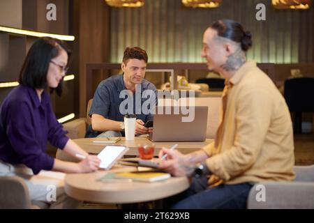 Smiling mature businessman working on laptop in coworking space Stock Photo