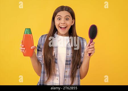 haircare of amazed teen girl with hairbrush. teen girl taking care of her hair with a hairbrush, haircare. teen girl haircare by combing hair isolated Stock Photo