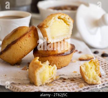 Pasticciotto leccese pastry filled with egg custard cream, typical sweet from Lecce, Italy. Pieces of pasticiotto on a beige napkin, apulian breakfast Stock Photo