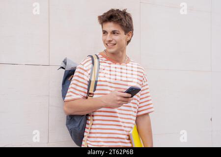 Happy student on campus using a social media app with smartphone outdoors. Stock Photo
