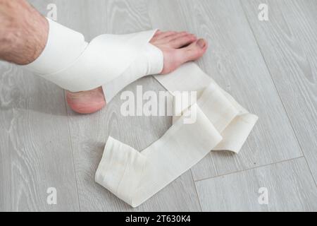 man using put on elastic bandage with legs having leg pain Stock Photo