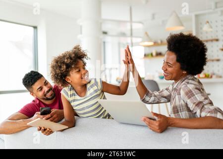 Family with laptop, tablet and smartphone at home, everyone using digital devices Stock Photo