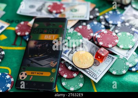 Cards, phone, casino chips and dice close up. Computer keyboard and smartphone, illuminated with pink light. Concept of gambling, online betting in Stock Photo