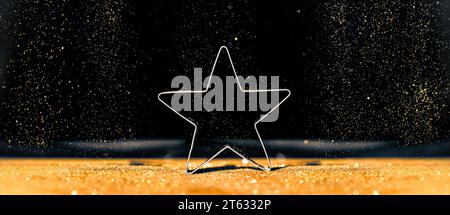 Star on Defocused Bokeh Background. Sparkling Christmas Ornament on Glitter Defocused Gold Lights. Stock Photo