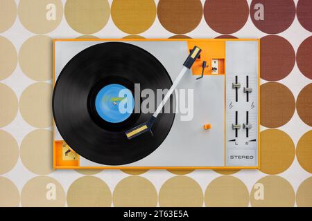 Top view of an orange vintage record player in front of retro brown wallpaper Stock Photo