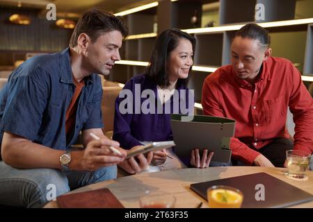 Group of cheerful colleagues working on project documentation Stock Photo