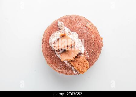 Tiramisu fancy brioche doughnut with topping of honey biscuits and whipped cream. Stock Photo